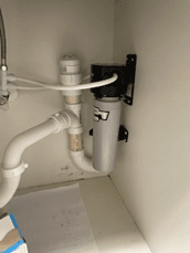 An activated carbon filter installed beneath a sink