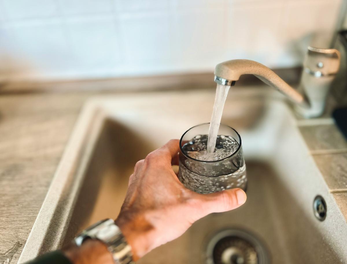 Filling a testing bottle at a kitchen tap